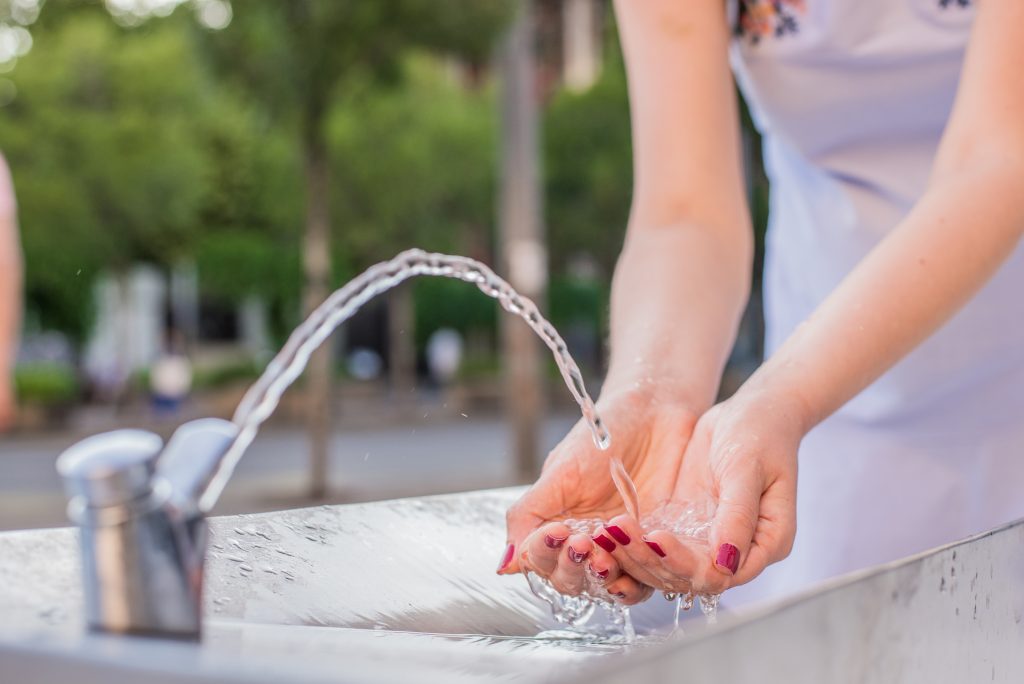 obrazek przedstawiający kobietę pijącą wodę z kranu